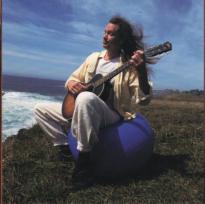 Michael playing guitar on the headlands by the ocean