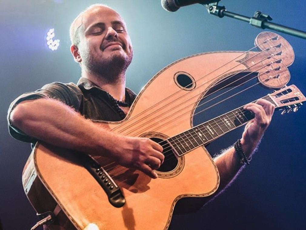 Andy McKee playing harp guitar on stage