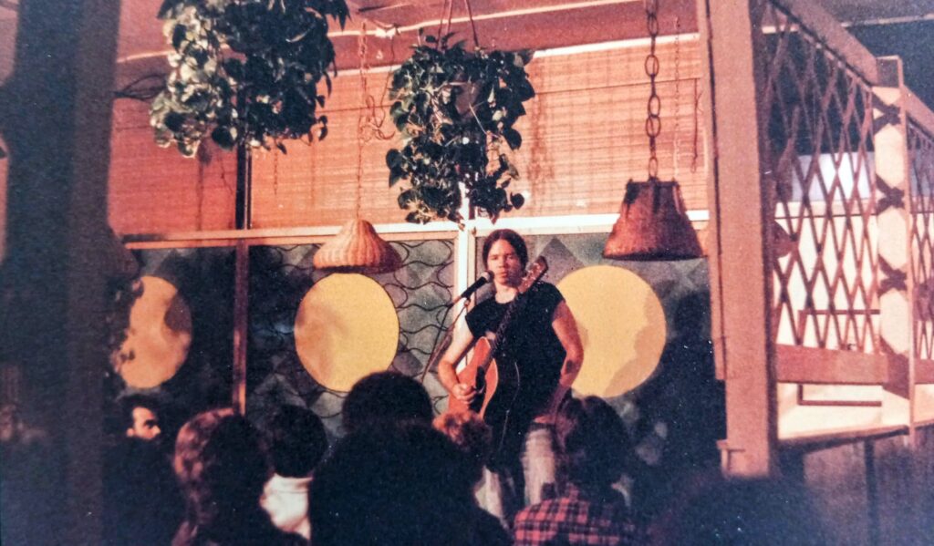 Guitarist Michael Hedges with long hair, playing in a restaurant