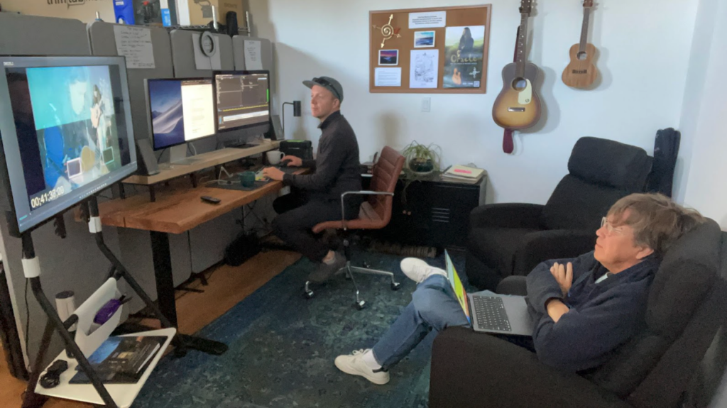 Two film directors sit in a film editing room, working on Michael Hedges documentary
