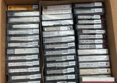 Dozens of hi-8 video cassettes, labeled for ORACLE filmmakers