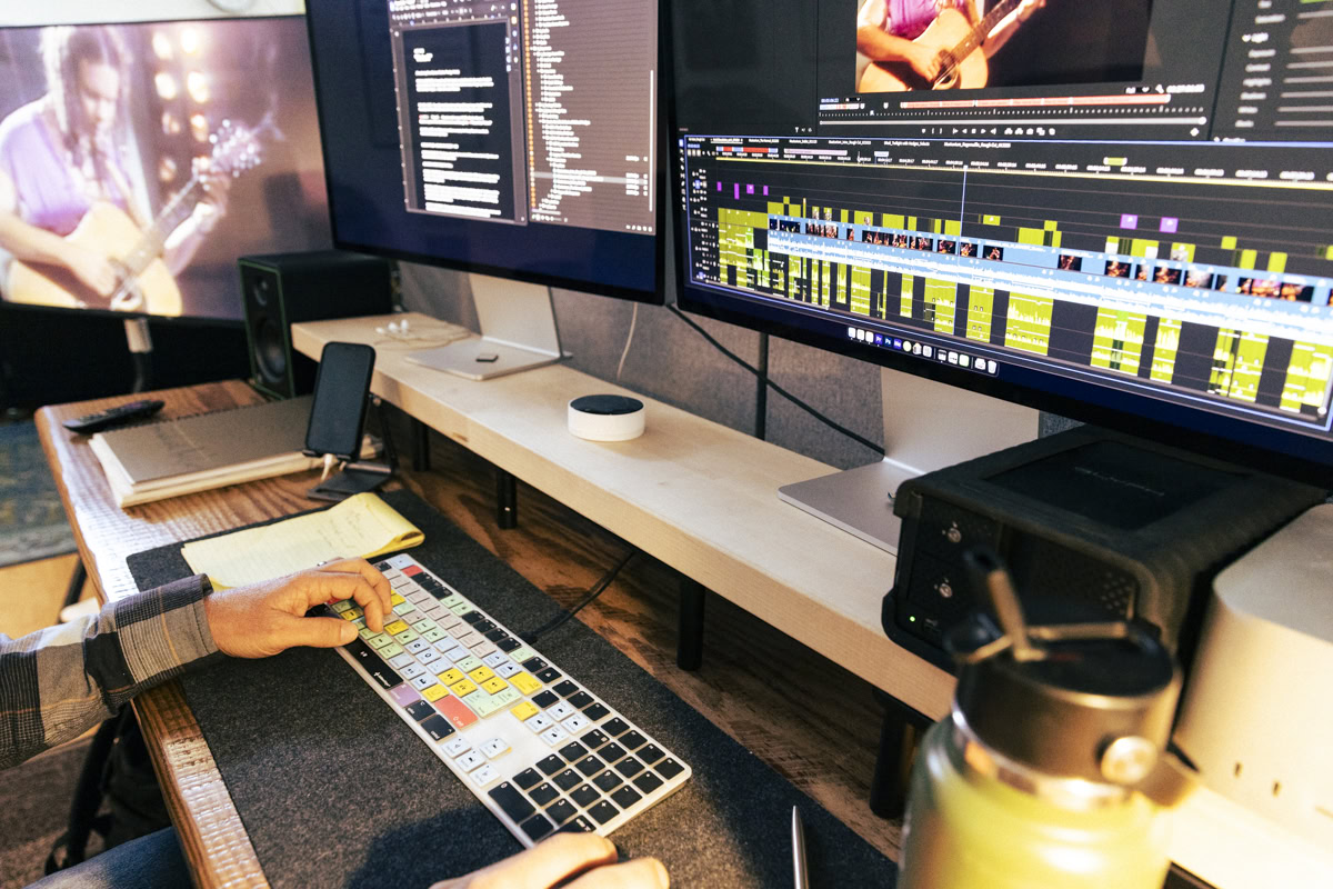 Film editor's desk with keyboard and screens.