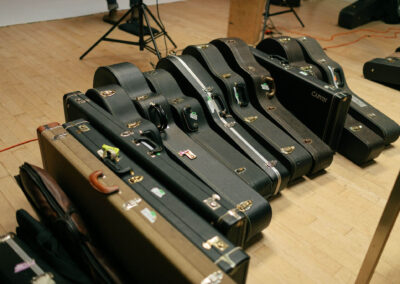 Michael's guitars lined up, ready to be photographed, as Oracle documentary crew films the process. Photo Credit: Monica Semergiu