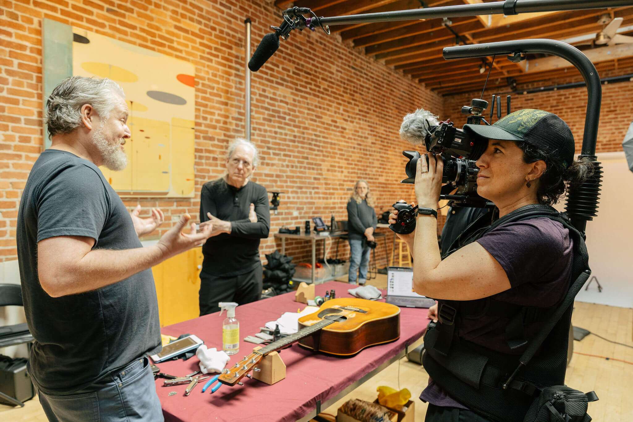 Director of Photography Clare Major films biographer Jake White telling a story about "Barbara", Michael's Martin D-28. Photo Credit: Monica Semergiu