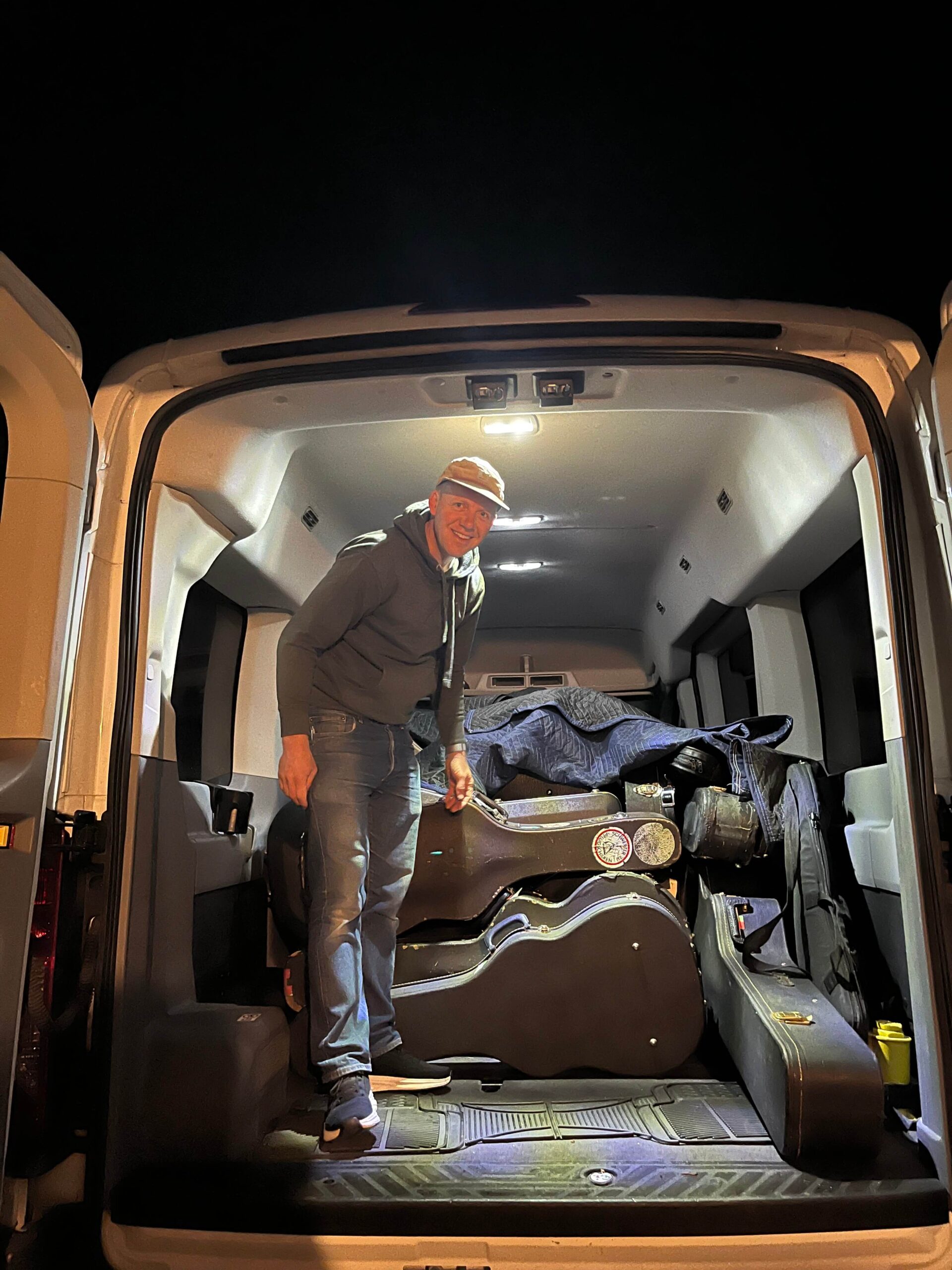Mischa Hedges loading guitars into a cargo van. Photo Credit: Brendan Hedges